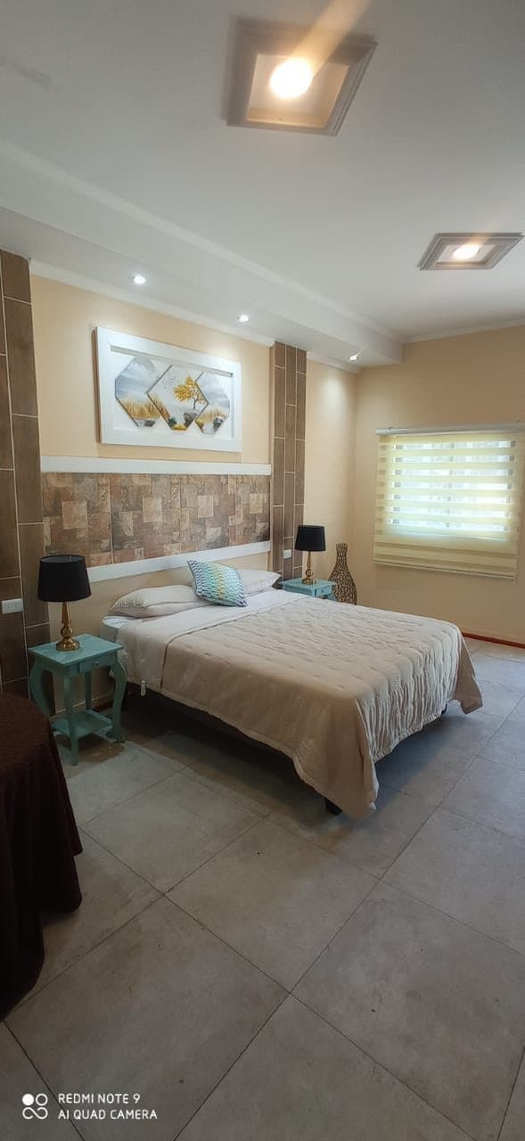 Habitación matrimonial con velador y ventana