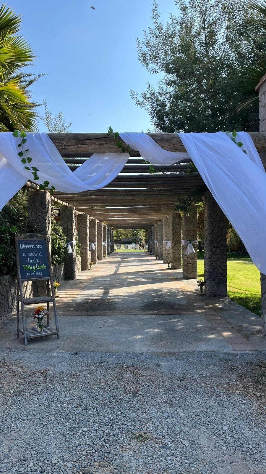 Pérgola de madera decorada con telas blancas para una ceremonia de matrimonio