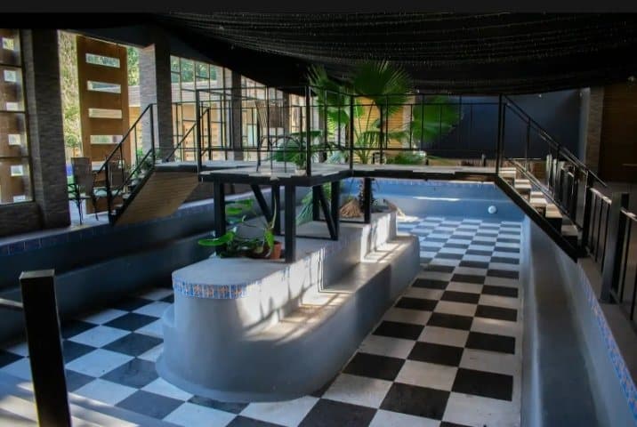 Salón con piscina interior de piso ajedrezado, de día