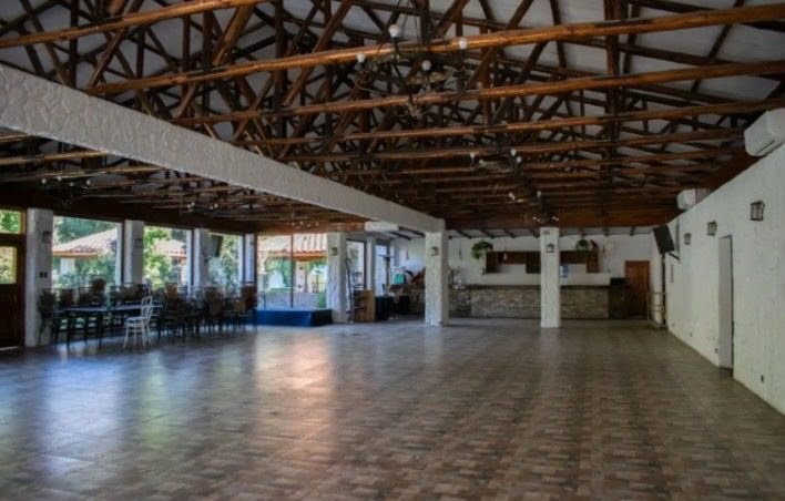 Salón principal con techumbre de madera y ventanales al jardín