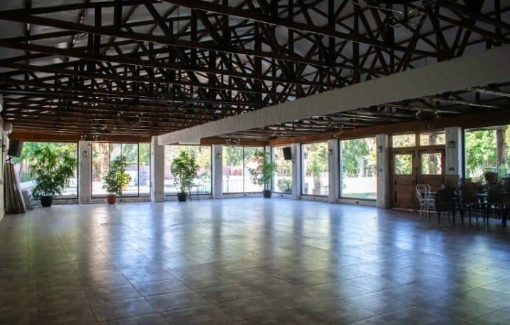 Salón de eventos amplio con ventanales y vista a los jardines