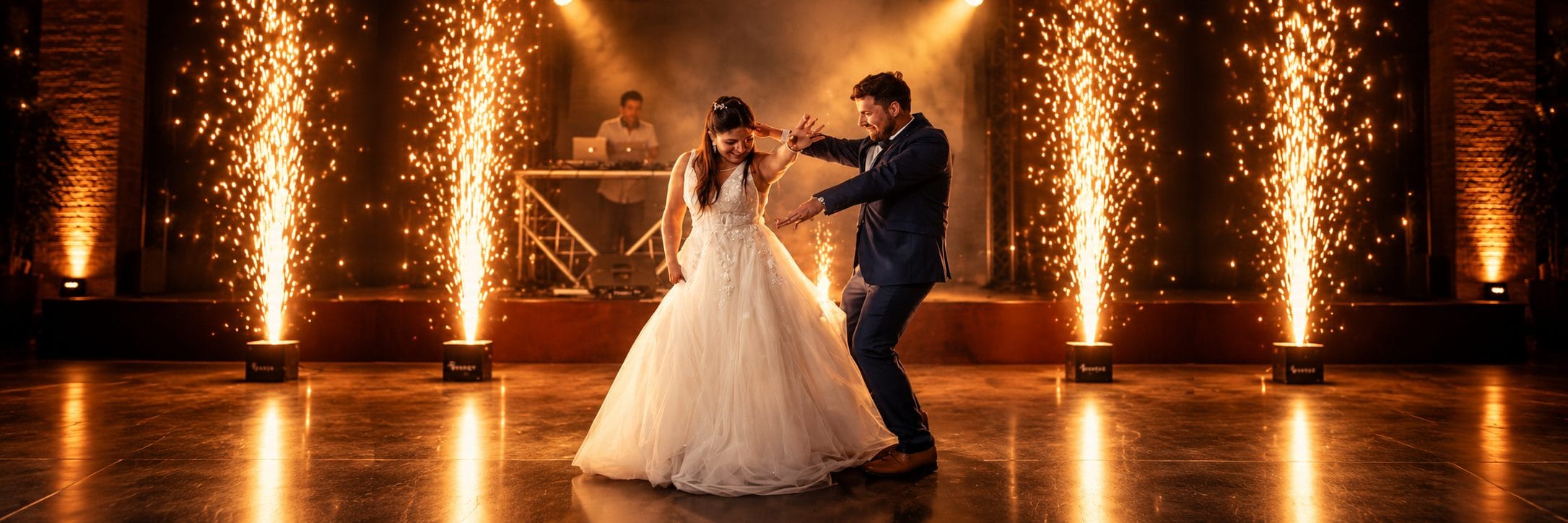 Novios bailando en la pista del salón entre fuentes de chispas